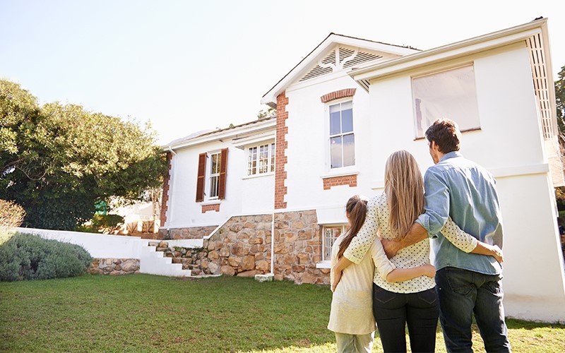 family-standing-outside-admiring-their-home